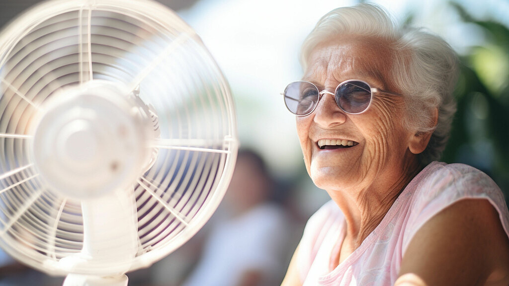 Eine älter Frau vor einem Ventilator